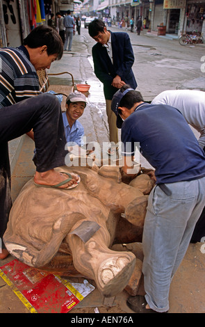 China Yunnan Jinghong Handwerk arbeiten an großen hölzernen Elefanten schnitzen Stockfoto