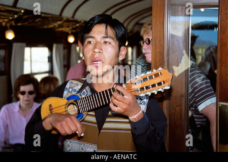 Mann spielt Gitarre in peruanische Band im Schlitten von Puno nach Cusco Perurail Zugfahrt, Peru Stockfoto