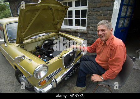 Mann, sitzend von seinem Auto (Jim Somerfield) Festsetzung einer Austin Wolsley englische Oldtimer Llansawel Carmarthenshire Südwales Stockfoto