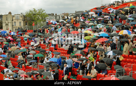 Zuschauer, die ihre Schirme als Regen Interupts Aufmachungen spielen Tennis Championships im Artois Queens in London England Stockfoto