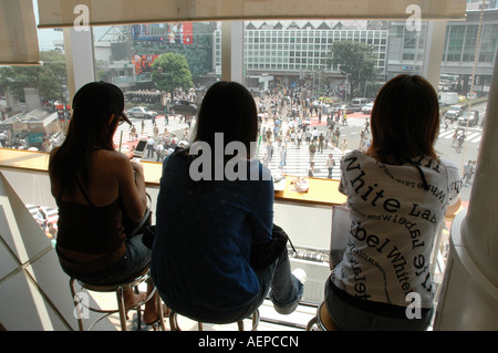 Studenten, die aus dem Fenster von Starbucks Cafe in Shibuya, Tokio Japan Fußgängerüberweg Bahnhof Stockfoto