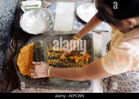 Goan Indianerin Schleifen Kokos und Chili für Curry mit flachen Granit Schleifstein FATOR in Konkani Sprache genannt. Goa Stockfoto