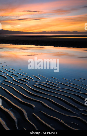 Sonnenuntergang und Sand kleine Wellen am Pohara Beach in Golden Bay, Neuseeland Stockfoto