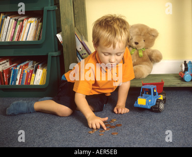 Kleiner Junge Münzen auszählen Stockfoto