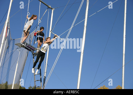 Frau Trapezkünstler springt Plattform, während zwei Frauen schauen auf Stockfoto
