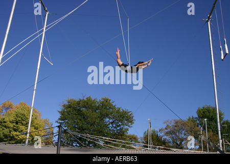 Frau Trapezkünstler fliegt über das Netz Stockfoto