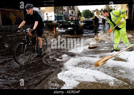 Pendler, die ihren Weg durch Hochwasser nach einem Freak Hagelsturm im Zentrum von London, im Sommer 2007. Stockfoto