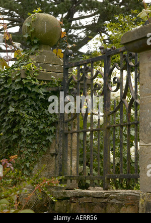 Schmiedeeisernes Tor in Efeu bedeckt alte Steinmauer an Borde Hill Gardens, Sussex Stockfoto