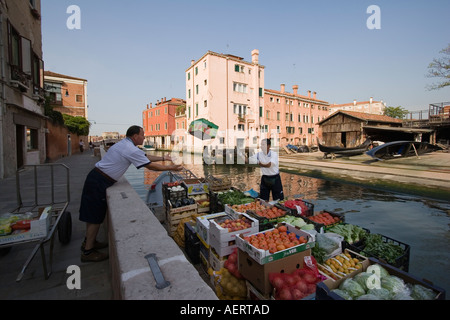 Männer entladen Boxen von Produkten auf Rio de S Trovaso Dorsoduro Venedig Italien Boot Stockfoto