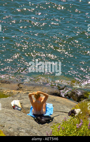 Eine junge Frau, Sonnenbaden in Djurgården Stockholm Schweden EU Stockfoto