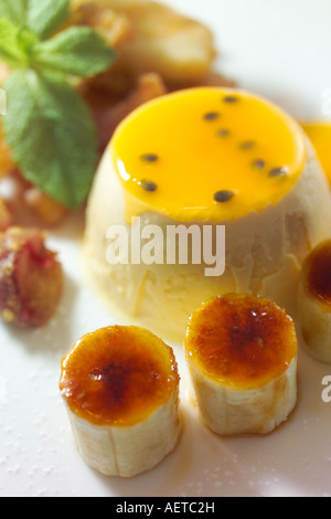 White Chocolate Ice Cream mit Mangosauce und karamellisierten Bananen. Stockfoto