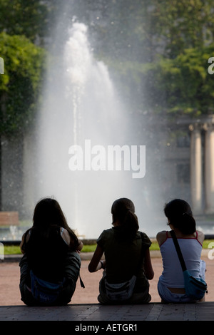 Drei junge Mädchen beobachten Brunnen in Dona Casilda Iturrizar Park Bilbao Stockfoto