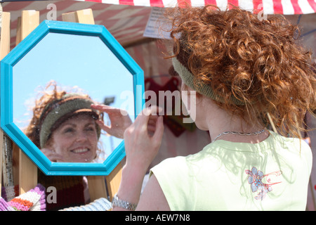 Mädchen an Verkaufsautomaten stall verkaufen Wollens, Hut, junge Frau tragen & Verkauf woolly Hüte auf sonnigen Tag Portsoy, Morayshire in der Nähe von Inverness Schottland Großbritannien Stockfoto