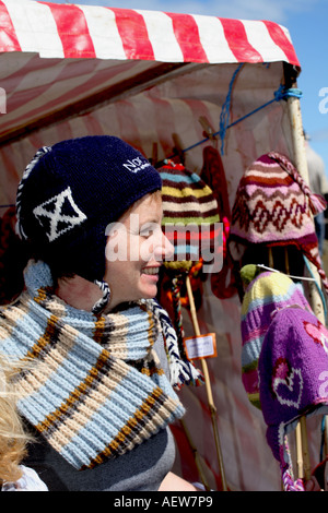 Mädchen an Verkaufsautomaten stall verkaufen Wollens, junge Frau tragen & Verkauf woolly Hüte auf sonnigen Tag Portsoy, Morayshire in der Nähe von Inverness Schottland Großbritannien Stockfoto