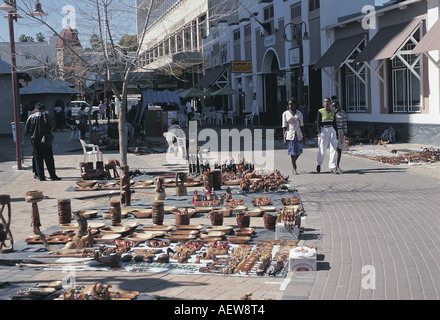 Drei junge afrikanische Frauen Spaziergang vorbei an Holzschnitzereien auf dem Bürgersteig in Windhoek Namibia Südwest-Afrika Stockfoto