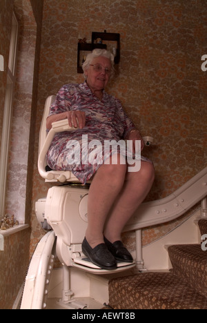 81 Jahre alte Seniorin mit Treppenlift, Treppen, London, UK aufzusteigen. Stockfoto