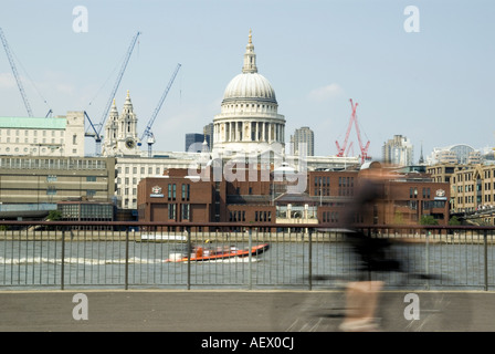 Verschwommene Radfahrer am Südufer mit St. Pauls Kathedrale und City of London im Hintergrund Stockfoto