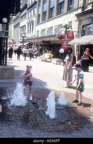 Kinder genießen eine Spaß-Wasser-Funktion in einer Fußgängerzone, Einkaufszentrum in Ottawa, Ontario, Kanada Stockfoto