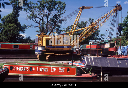 Werft auf Shropshire Union Canal mit Kran, umgeben von klassischen traditionellen arbeiten Narrowboats, Stretton Wharf, England Stockfoto