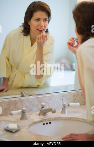 Frau Lippenstift im Badezimmer Stockfoto