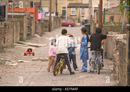 Asiatische Kinder spielen in einer gepflasterten Seitenstraße in Bradford, Yorkshire Stockfoto