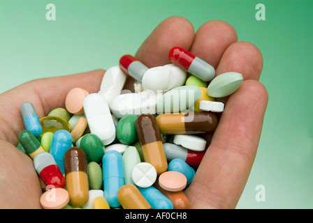 Hand, gefüllt mit Pillen in verschiedenen Farben und Formen Stockfoto