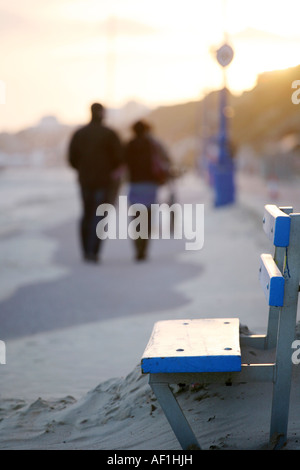 Paar zu Fuß entlang Bournemouth Strand Sonnenuntergang Stockfoto