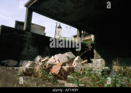 Blick auf Kirchturm durch zerstörte Gebäude in der Nähe von Srebrenica Stadtzentrum, Bosnien. Stockfoto