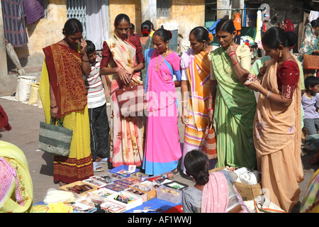 Eine Gruppe indischer Frauen, die am Schmuckstand im Markt einkaufen, Vanakbara Fishing Village, Diu Island, Gujarat, Indien Stockfoto