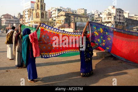 Indische Frauen, die Saris halten, um in der Sonne am Ramkund Badebecken, Nasik, Maharashtra, Indien zu trocknen Stockfoto