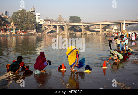 Indische Frauen waschen Kleidung am frühen Morgen in Ramkund Badetank, Nasik, Maharashtra, Indien Stockfoto