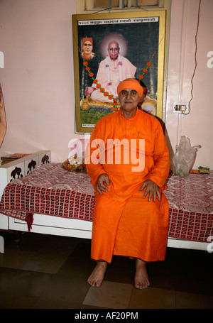 Hindu-Priester sitzt auf dem Tagesbett in seinem Viertel, Pune, Indien Stockfoto