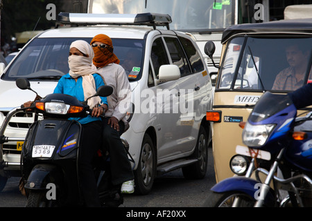 Indische Frauen Reiten Roller ohne Helm im geschäftigen Verkehr, Pune, Indien Stockfoto