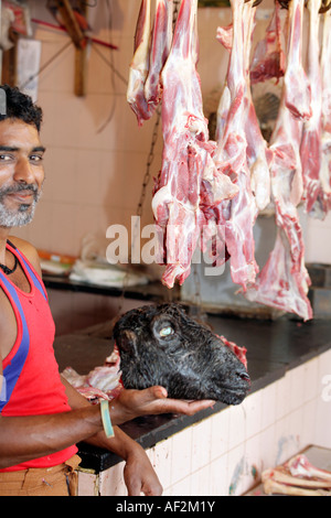 Halal Metzger holding Ziege Schädel im Store verkaufen Hammel- und Schaffleisch exklusiv. Margao New Market in Goa Indien Stockfoto