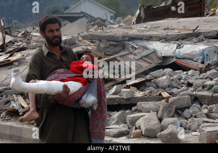 Ein Vater trägt seine verletzten Tochter durch Balakot, nach eine Erdbeben der Stärke 7,6 Pakistan, 8. Oktober 2005 geschlagen. Stockfoto