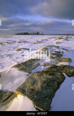 Winterschnee bedeckt die Felsen und Lake Michigan Shore kurz nach Sonnenaufgang, USA, Wisconsin, Door County Stockfoto