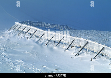 Schottische Winterszene - Schneezaun nach Schneesturm im Glenshee Ski Centre, Braemar, Schottland Cairngorms National Park, Großbritannien Stockfoto