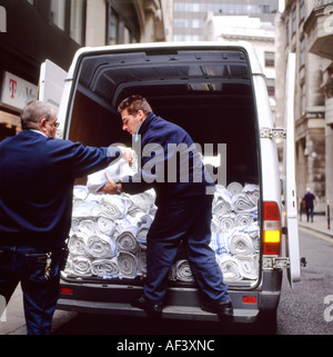 Zwei Männer, die Bereitstellung von Wäsche Leinen von der Rückseite eines Transporters gestoppt in einem Fenchurch Bereich Straße Stadt von London England UK KATHY DEWITT Stockfoto