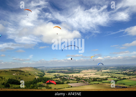 Gleitschirme fliegen in den Wolken über den South Downs am Devils Dyke Beauty Spot in Sussex Stockfoto