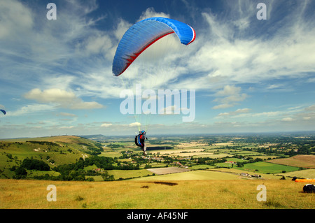 Ein Gleitschirm schwingt sich in die Wolken über den South Downs an den National Trust Devils Dyke Ausflugsort in Sussex Stockfoto