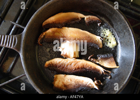 Portobello-Pilze in Scheiben geschnitten und in Pfanne mit zerlassener Butter Kochen Stockfoto