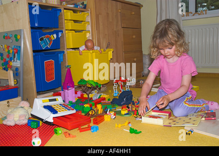 Kleine Mädchen spielen in ihrem chaotisch Spielzimmer Stockfoto