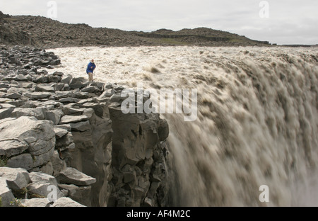 Dettifoss-Wasserfall im Nord-Ost-Island mit einem Touristen auf den Felsen Stockfoto