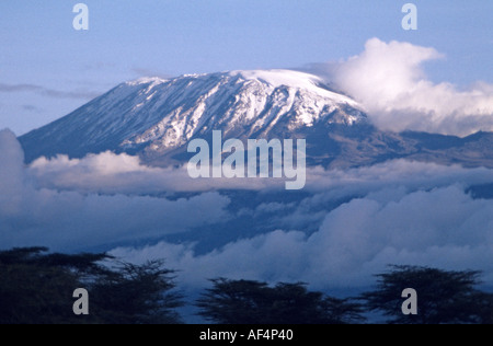 Mount Kilimanjaro Tanzania in der späten Nachmittag Sonne bekränzt in niedrigen Wolken um den Gipfel von Amboseli Kenia gesehen Stockfoto