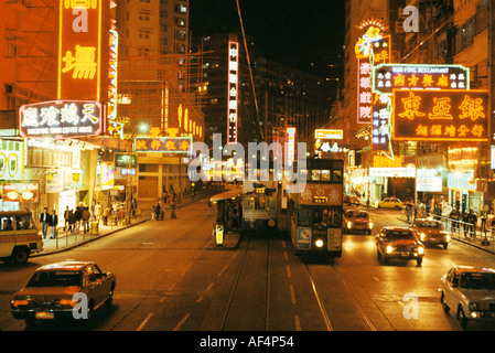 Blick bei Nacht in den späten 1970er Jahren von einer breiten Straße in Causeway Bay mit Straßenbahnen Autos und hellen Neon Schilder Hong Kong Stockfoto