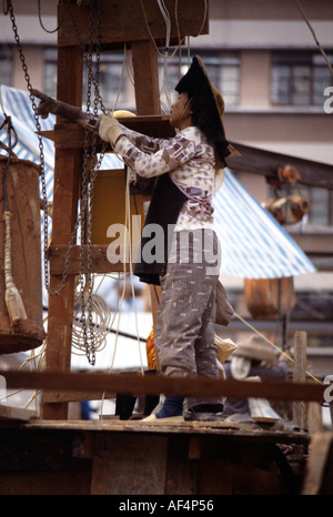 Eine Hakka Frau in runden Hut mit breiter Krempe mit schwarzen hängenden Fransen arbeiten auf der Baustelle in den späten 1970er Jahren Hongkong Stockfoto