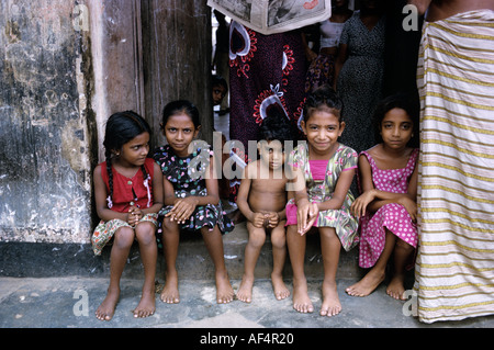 Gruppe von fünf einheimischen Kindern sitzt schüchtern in einer Straße Tür in Colombo Sri Lanka Stockfoto