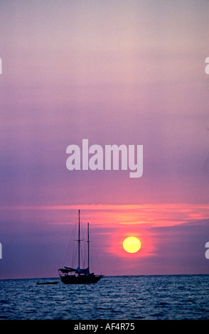 Klassische orange und gelbe Sonnenuntergang mit Ball der Sonne über dem Meer in der Nähe von Horizont mit Yacht St.Petersburg Florida USA Stockfoto