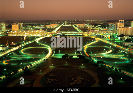 Luftaufnahme nach Sonnenuntergang mit rotem Himmel und Stadt beleuchtet mit leichten Spuren der Autolichter in der Abenddämmerung über Brasilia Goias Brasilien Stockfoto
