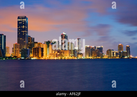 Lichter funkeln in Bürogebäuden Hochhaus dieser Linie Brickell Avenue da Dämmerlicht Biscayne Bay, Miami, Florida wiedergibt. Stockfoto